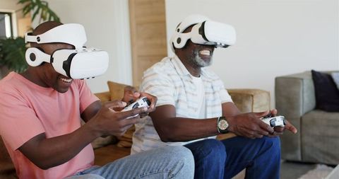 Father and Adult Son Enjoying Virtual Reality Gaming Together