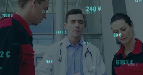 Doctor Discussing Patient Care with Paramedics in Hospital Lobby