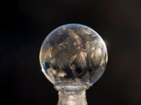 Close-up of frozen soap crystal ball bubble with intricate frost patterns