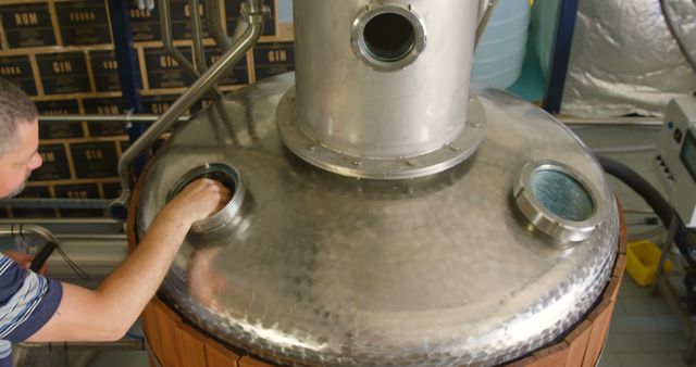 Distillery worker inspecting equipment in alcohol production facility - Download Free Stock Images Pikwizard.com