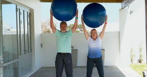 Active Seniors Exercising with Fitness Balls in Outdoor Space