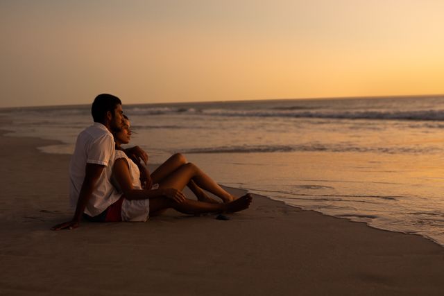 Couple looking at sea on the beach during sunset - Download Free Stock Photos Pikwizard.com