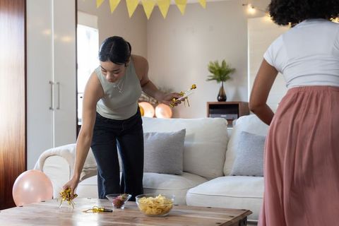 Women Arranging Festive Decorations in Cozy Living Room