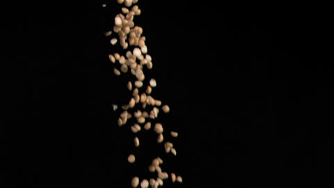 Peanuts Falling in Slow Motion Against Black Background