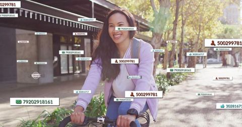 Smiling woman biking in city with technology elements