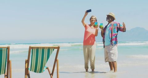 Senior Couple Enjoying Beach Selfie Cheers