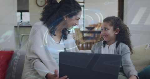 Mother and daughter sharing laptop on couch with futuristic hud overlay for remote learning