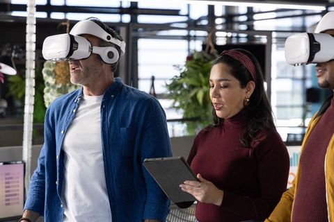 Diverse team testing vr headsets in open-plan workspace for training and collaboration
