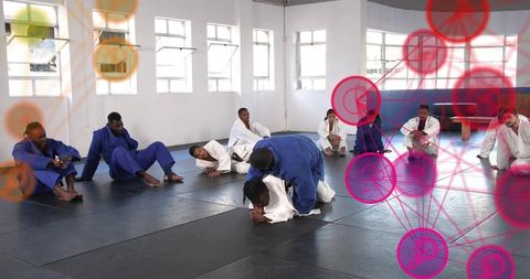 Brazilian jiu-jitsu class grappling practice on black mats with blue and white gis