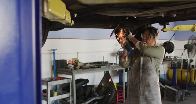 Female Mechanic Welding Under Car in Automotive Workshop - Download Free Stock Images Pikwizard.com