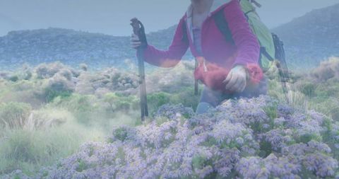 Woman exploring nature holding trekking pole with vibrant backpack