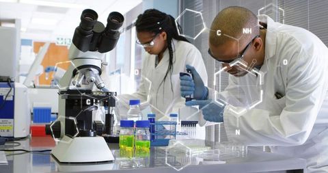 Two Scientists Using Pipette Transferring Reagents into Multiwell Plate for Biotech Assay