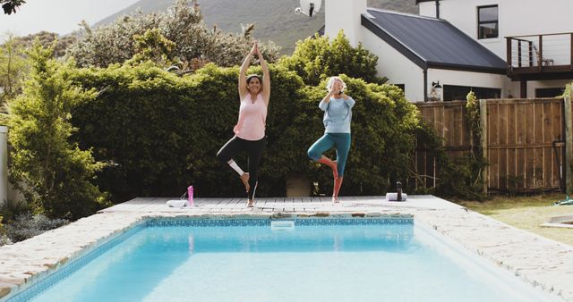 Two Women Practicing Yoga Poses by Poolside in Outdoor Garden - Download Free Stock Images Pikwizard.com