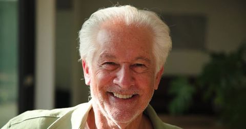 Smiling Senior Man Relaxing at Home in Natural Light