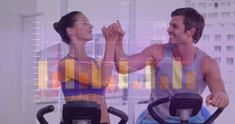 Couple Exercising on Stationary Bikes with Financial Data Overlay