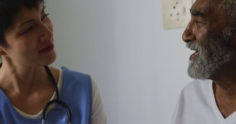Senior Man Speaking with Caring Nurse in Healthcare Setting