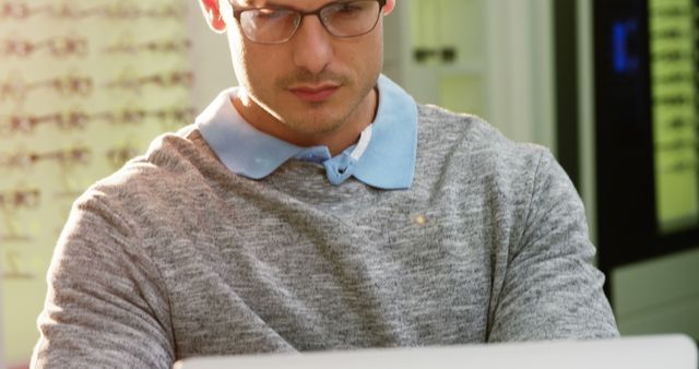 Focused Young Man Working on Laptop in Office Setting - Download Free Stock Images Pikwizard.com