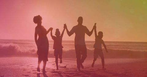 Joyful Family Holding Hands on Beach at Dusk Silhouette