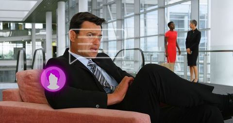 Businessman Engaging with Digital Communication Icon in Modern Interior