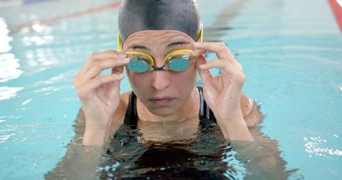 Female Swimmer Adjusting Goggles for Intense Training Session