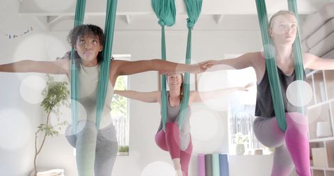 Diverse Group Practicing Aerial Yoga for Wellbeing and Fitness