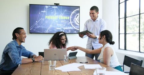 Diverse team celebrating successful project launch in modern office