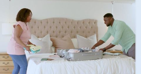 Excited couple packing suitcase for vacation travel