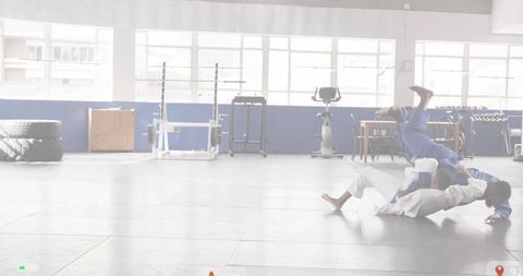 BJJ partners grappling on mats in bright dojo with fitness gear and generous copy space