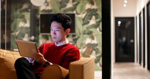 Focused Male Executive Using Digital Tablet on Office Sofa