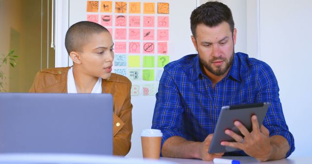 Two Colleagues Discussing Work at Desk with Tablet and Laptop - Download Free Stock Images Pikwizard.com