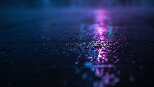 Neon reflections on wet urban pavement at night with purple and cyan bokeh