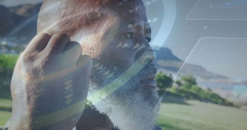 Senior man engages with technology using wireless earbuds outdoors