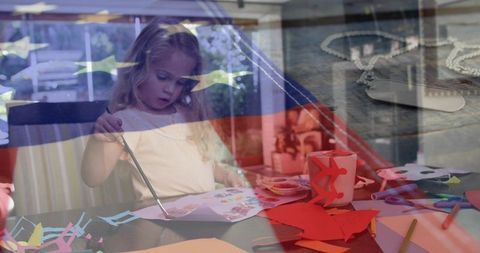 Child painting crafts with patriotic flag overlay and dog tag necklace double exposure