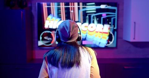 Teen Gamer Engaged in Video Game on Large Screen