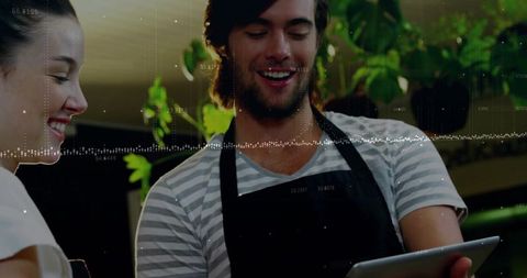 Barista team discussing digital cafe trends on tablet