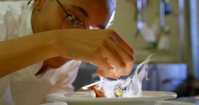 Young Chef Preparing and Garnishing a Gourmet Dish in a Professional Kitchen - Download Free Stock Images Pikwizard.com