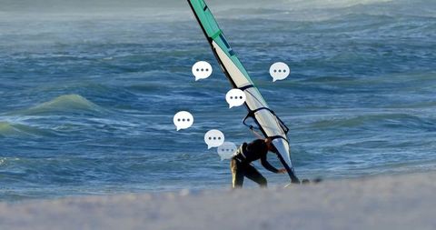 Man Adjusting Windsurfing Sail on Sunny Beach