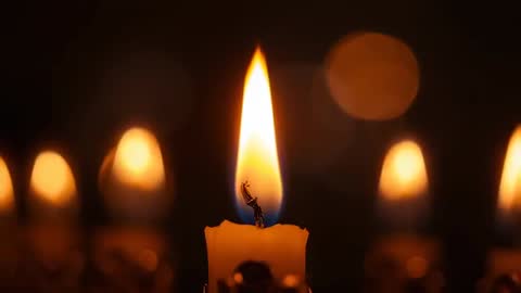 Serene Candle Flame Flickering with Warm Bokeh Background