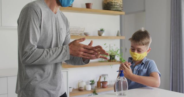 Father and son using hand sanitizer wearing protective masks at home - Download Free Stock Images Pikwizard.com