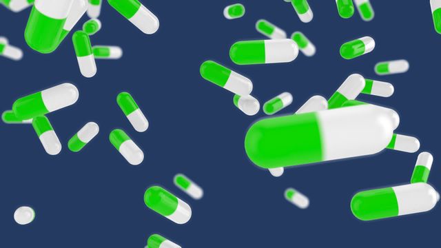 Capsules in vibrant green and white colors scatter across a deep blue canvas. Useful for illustrating topics in the pharmaceutical industry, healthcare communication, or medicine advertising. Ideal for visuals requiring emphasis on treatment, medication design, or innovations in global medication channels.