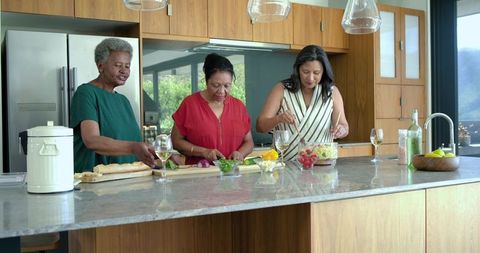 Multigenerational african american women preparing healthy meal together in modern kitchen