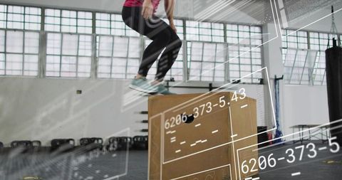 Leaping woman landing on plyo box during high-intensity workout with hud overlays