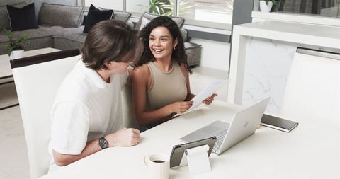 Interracial Couple Collaborating on a Project in Cozy Living Room