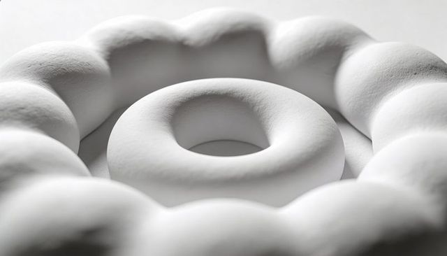 Minimal white concentric torus sculpture with beaded ring and matte porous surface