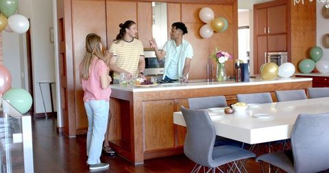 Friends Chatting in Modern Kitchen During Casual Gathering