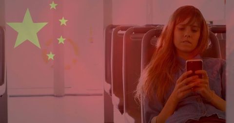 Commuter using smartphone with red flag overlay on bus