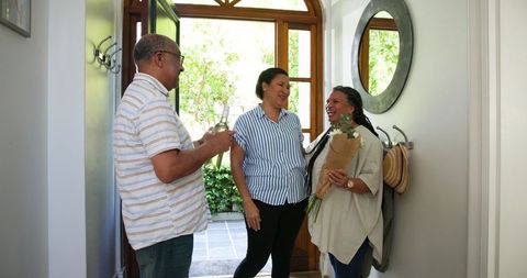 Senior Friends Reunion with Wine and Flowers at Home