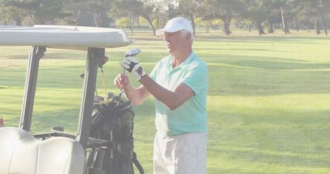 Senior golfer selecting club from bag on scenic fairway