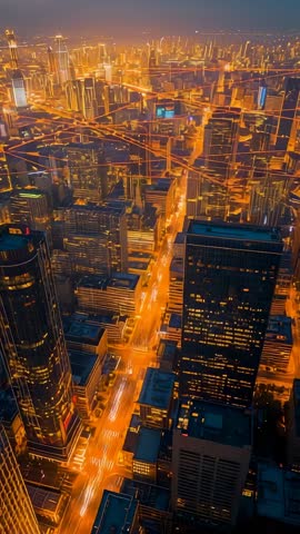 Vertical aerial revealing city lights switching on over downtown grid while tilting down