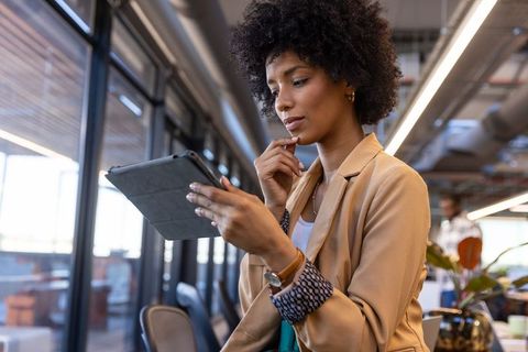 Focused Businesswoman Reviewing Digital Information on Tablet